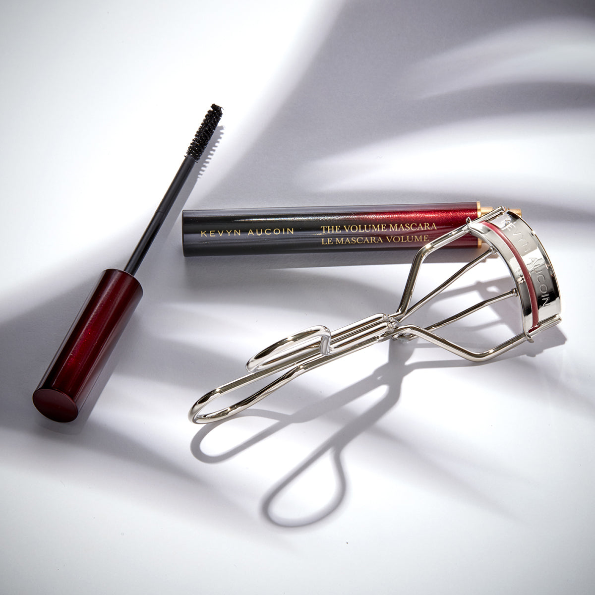 Kevyn Aucoin eyelash curler & Volume Mascara sitting on white surface
